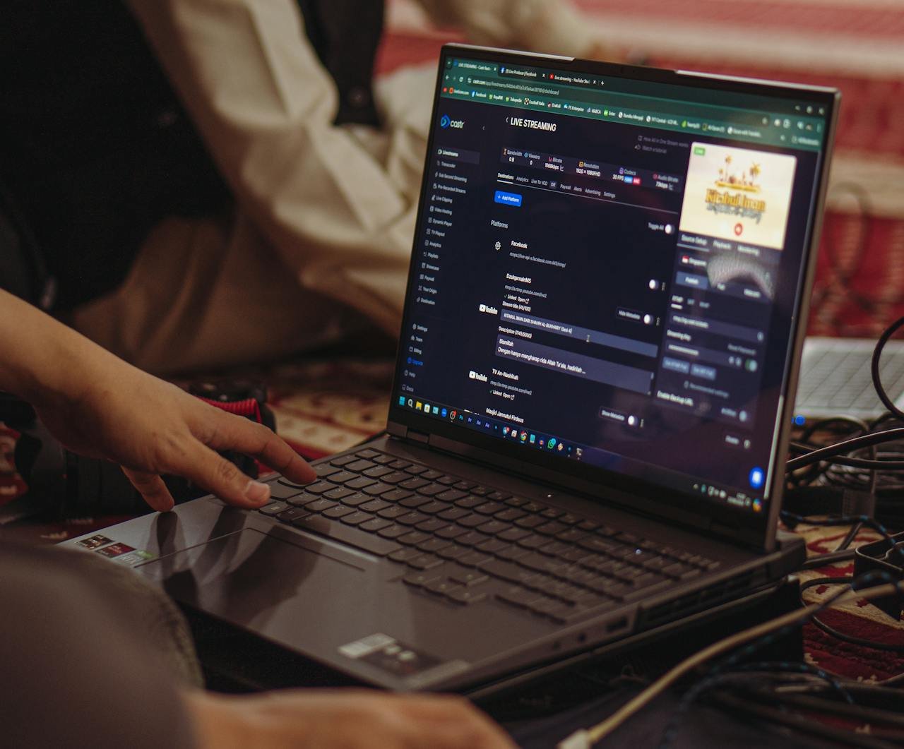 A person setting up a live stream on a laptop, emphasizing technology and connectivity.